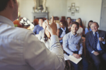 Business people in audience watching businessman leading business conference - CAIF05566