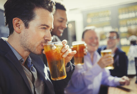 Mann trinkt Bier mit Freunden an der Bar - CAIF05582