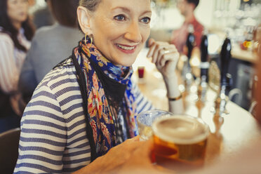 Senior woman drinking beer at bar - CAIF05597