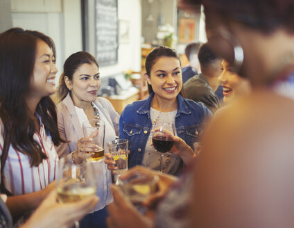 Freundinnen unterhalten sich und trinken Bier und Wein an einer Bar - CAIF05598