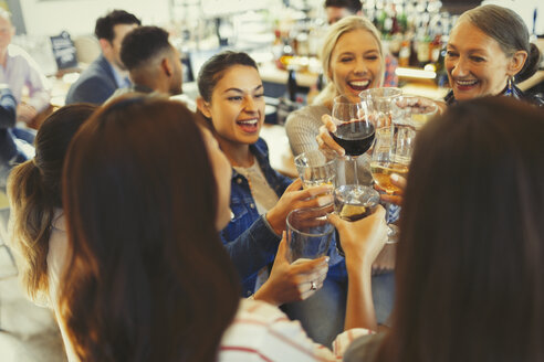 Enthusiastische Freundinnen feiern, stoßen mit Bier- und Weingläsern in einer Bar an - CAIF05608