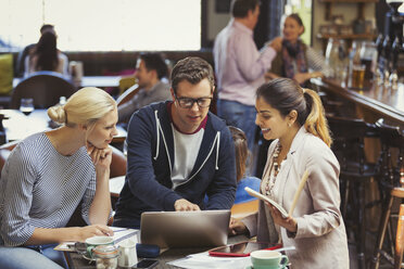 Creative business people meeting, using laptop in cafe - CAIF05612