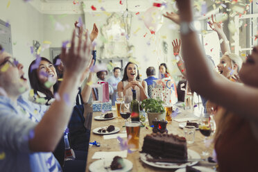 Freunde feiern Geburtstag und werfen Konfetti über dem Tisch im Restaurant - CAIF05632