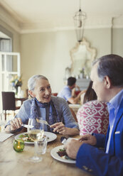 Älteres Paar, das sich am Restauranttisch unterhält und speist - CAIF05637