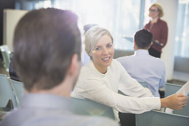 Smiling businesswoman talking to businessman in conference audience - CAIF05697