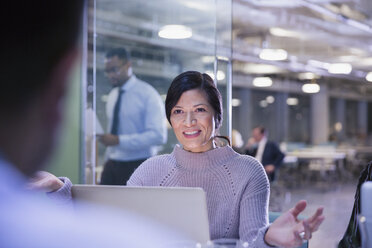 Businesswoman gesturing, talking at laptop in conference room meeting - CAIF05704