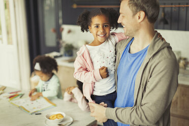 Porträt lächelnder multiethnischer Vater und Tochter in der Küche - CAIF05722