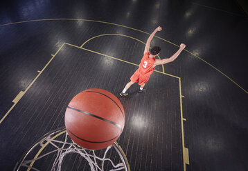 Confident young male basketball player shooting the ball and gesturing, celebrating - CAIF05858