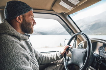 Young man with woolly hat and beard on a road trip - GUSF00421