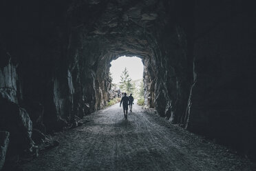 Canada, British Columbia, Kelowna, Myra Canyon, hikers on Kettle Valley Rail Trail crossing a tunnel - GUSF00425
