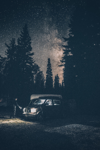 Kanada, Britisch-Kolumbien, Chilliwack, Mann mit Taschenlampe an Minivan bei Nacht, lizenzfreies Stockfoto