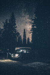Canada, British Columbia, Chilliwack, man with torch at minivan at night - GUSF00427