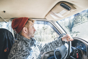 Young man with woolly hat and beard on a road trip - GUSF00430