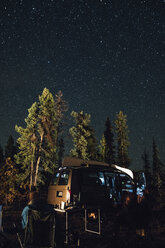 Kanada, British Columbia, zwei Männer sitzen unter dem Sternenhimmel in einem Minivan bei Nacht - GUSF00445