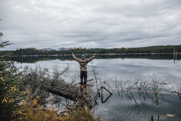 Kanada, British Columbia, Mann steht am Blue Lake und hebt die Arme - GUSF00452