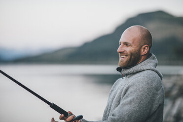 Canada, British Columbia, happy man fishing at Kinbasket Lake - GUSF00453