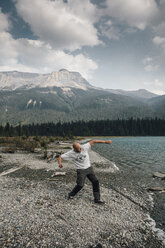 Kanada, Britisch-Kolumbien, Yoho-Nationalpark, Mann springt Steine am Emerald Lake - GUSF00458