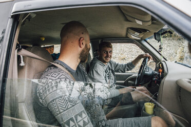 Zwei lächelnde junge Männer im Auto auf einer Autoreise - GUSF00486