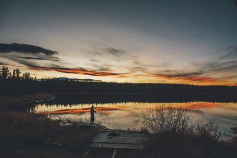 Kanada, British Columbia, Mann beim Angeln am Duhu Lake bei Sonnenuntergang, lizenzfreies Stockfoto