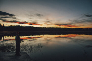Kanada, British Columbia, Mann beim Angeln am Duhu Lake bei Sonnenuntergang - GUSF00488