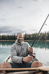 Kanada, British Columbia, Porträt eines glücklichen Mannes beim Fischen im Kanu auf dem Boya-See - GUSF00502