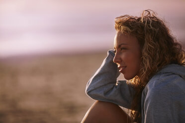 Pensive woman looking away on beach - CAIF05873