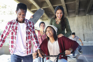 Teenager-Freunde mit Skateboards und BMX-Fahrrad im Skatepark - CAIF05930
