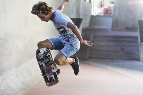 Jugendlicher kippt Skateboard im Skatepark - CAIF05941