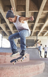 Jugendlicher, der auf einem Skateboard im Skatepark springt - CAIF05950