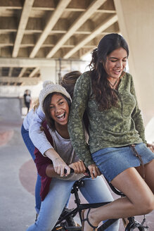 Verspielte Mädchen im Teenageralter fahren BMX-Fahrrad im Skatepark - CAIF05959