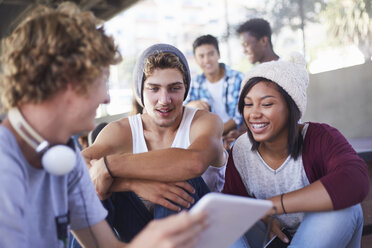 Freunde im Teenageralter hängen mit einem digitalen Tablet ab - CAIF05964