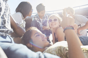 Teenager-Freunde hängen an einem sonnigen Tag ab und schreiben SMS - CAIF05970