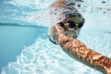 Männlicher Schwimmer, der im Schwimmbad unter Wasser schwimmt - CAIF05986