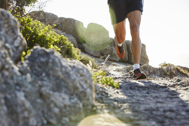 Male runner running on rocky trail - CAIF05990