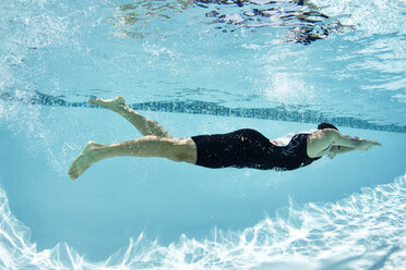 Männlicher Schwimmer, der im Schwimmbad unter Wasser schwimmt - CAIF05992