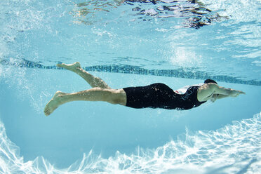 Male swimmer athlete swimming underwater in swimming pool - CAIF05992