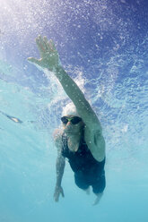 Male swimmer athlete swimming underwater in swimming pool - CAIF06002