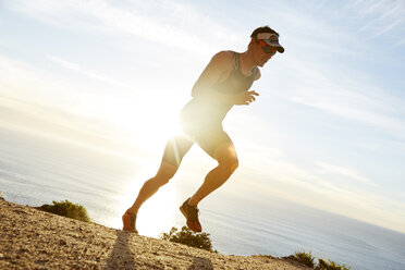 Männlicher Triathlet, der am Meer entlang läuft - CAIF06016