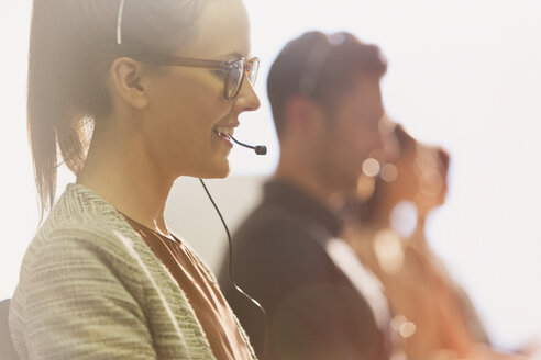 Nahaufnahme einer weiblichen Telefonverkäuferin mit Headset, die in einem Büro telefoniert - CAIF06031