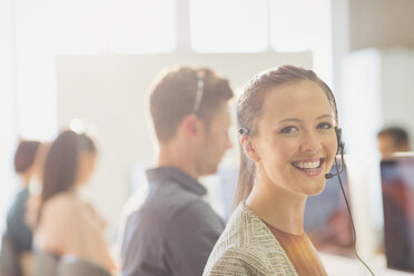 Portrait smiling female telemarketer wearing headset in office - CAIF06032