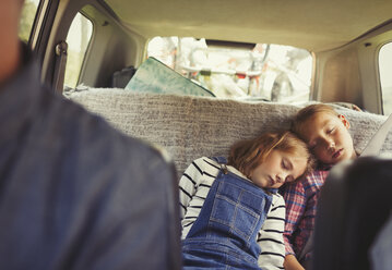 Müde Schwestern schlafen auf dem Rücksitz eines Autos - CAIF06059