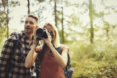 Ehepaar beim Wandern und Fotografieren im Wald mit digitaler Spiegelreflexkamera - CAIF06066