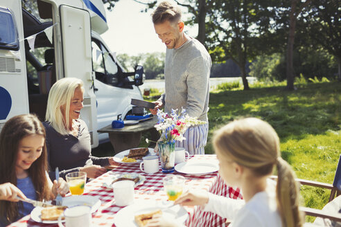 Familie beim Frühstück am Tisch vor dem sonnigen Wohnmobil - CAIF06098