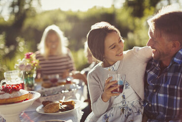 Liebevoller Vater und Tochter genießen eine sonnige Gartenparty - CAIF06115