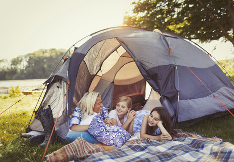 Mutter und Töchter unterhalten sich und entspannen sich im Zelt auf dem Campingplatz - CAIF06116