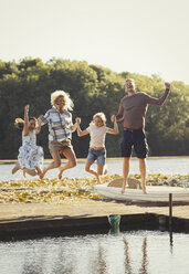 Porträt spielerische Familie springen auf sonnigen See-Dock - CAIF06130