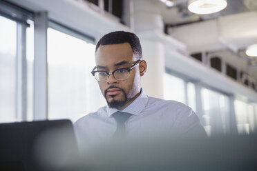 Serious, focused businessman working at laptop in office - CAIF06149