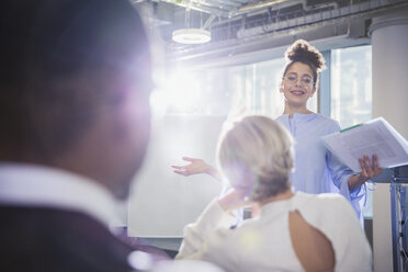 Businesswoman with paperwork leading conference room meeting - CAIF06180