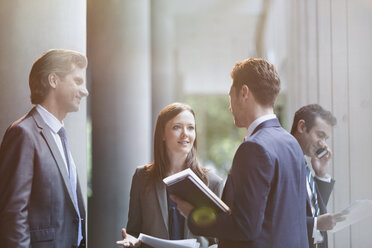 Business people talking in office lobby - CAIF06230