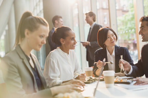 Geschäftsleute essen Sushi-Mittagessen mit Stäbchen im Konferenzraum - CAIF06272